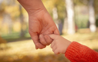 attachment style overview - parent and child holding hands with close-up on the hands